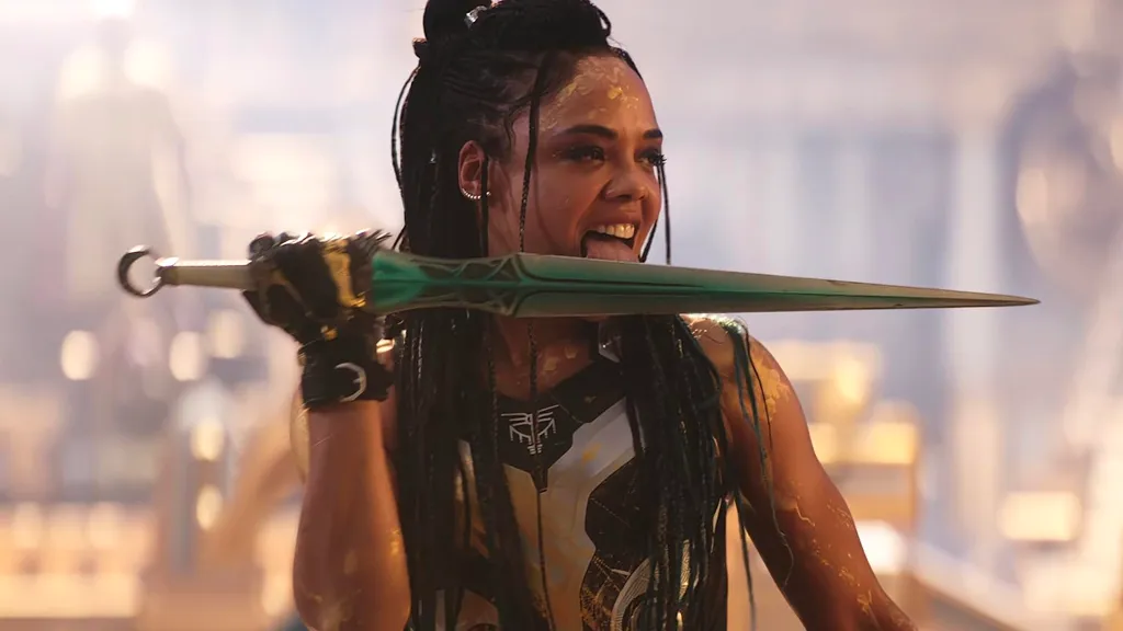 Tessa Thompson as Valkyrie licking a sword in Thor: Love and Thunder.