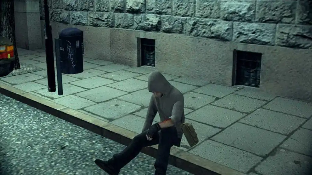 Simon sitting on a curb, looking down at his hands