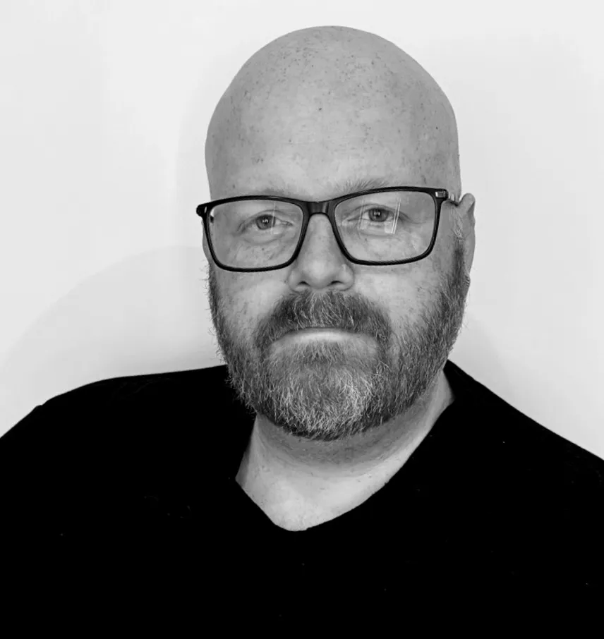 A tasteful, black and white image of ComicBook.com Executive Editor Simon Gallagher