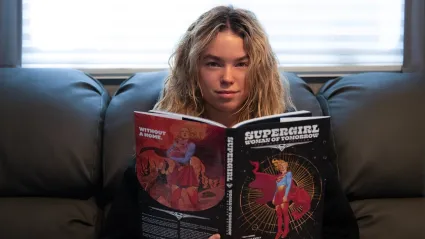 Milly Alcock as Supergirl reading the Woman of Tomorrow comic book
