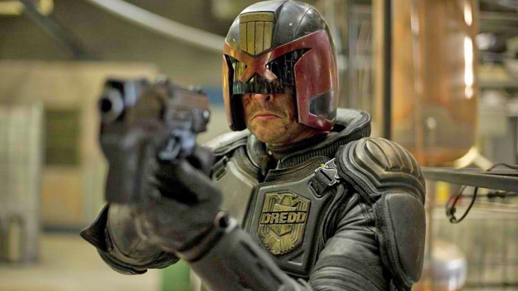 Karl Urban as Judge Dredd aiming his gun in Dredd