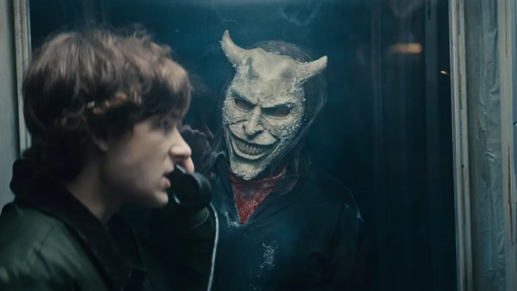 Ethan Harwke as the Grabber watching Mason Thames as Finney in The Black Phone 2