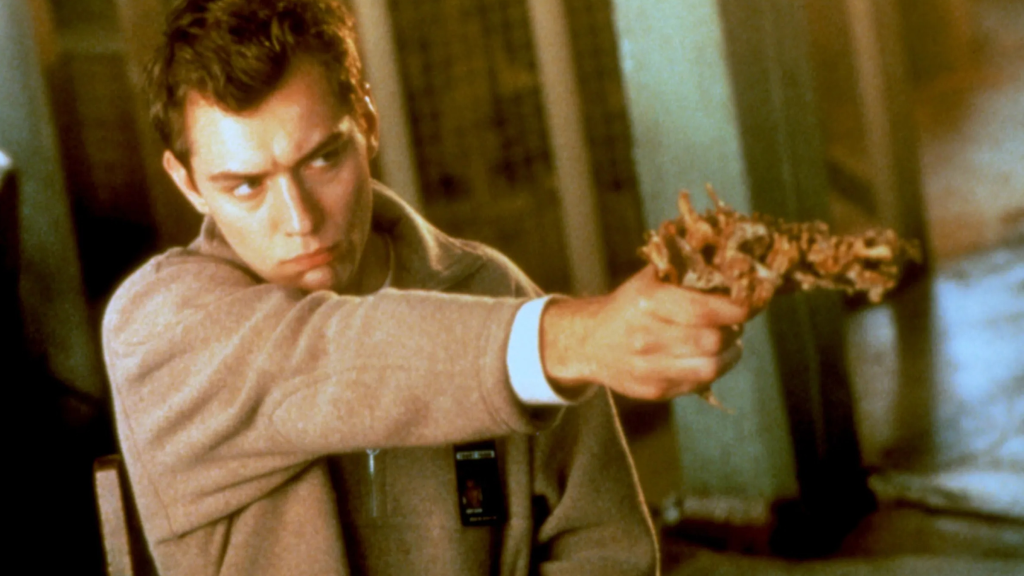 Jude Law aiming a weapon in Existenz (1997)