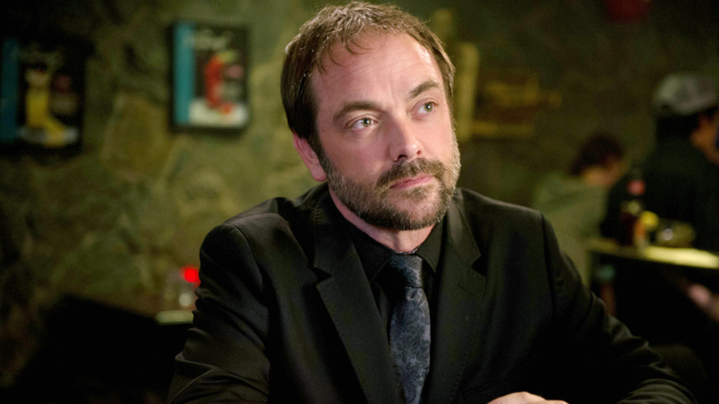 Mark Sheppard as Crowley staring at something off-screen in Supernatural