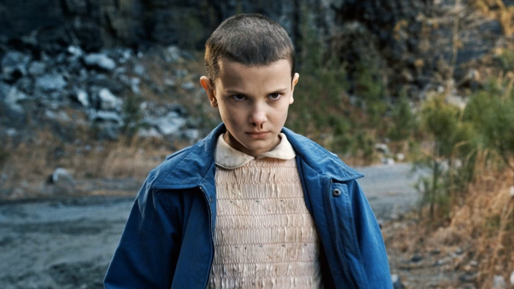 Millie Bobby Brown as Eleven looking angry and having a nosebleed in Stranger Things Season 1