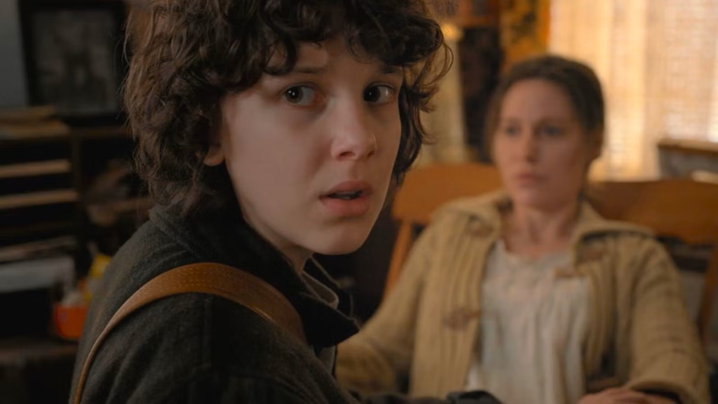 Eleven looking over her shoulder while kneeling in front of Terry Ives in Stranger Things Season 2