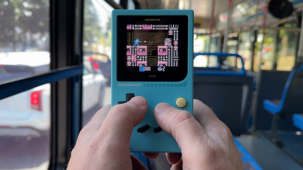 A person playing Mega Man on a ModRetro Chromatic.