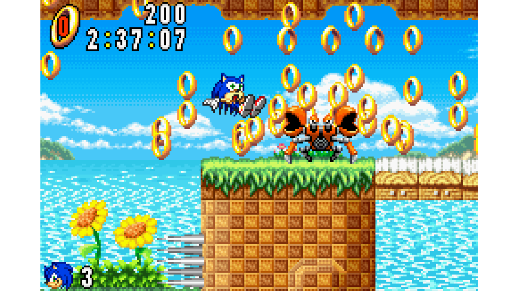 A screenshot from Sonic Advance, showing Sonic losing rings after being hit by a crab monster.