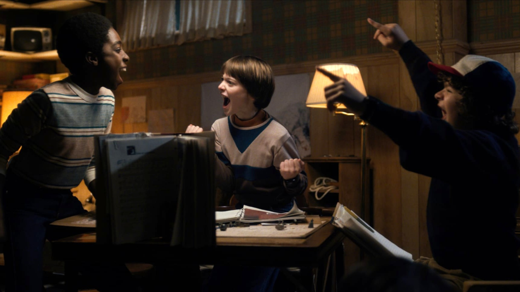 Lucas, Will, and Dustin celebrating while playing Dungeons & Dragons in Stranger Things