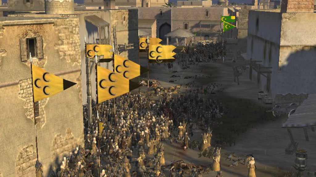 A screenshot from Medieval II: Total War, showing people moving through a city.