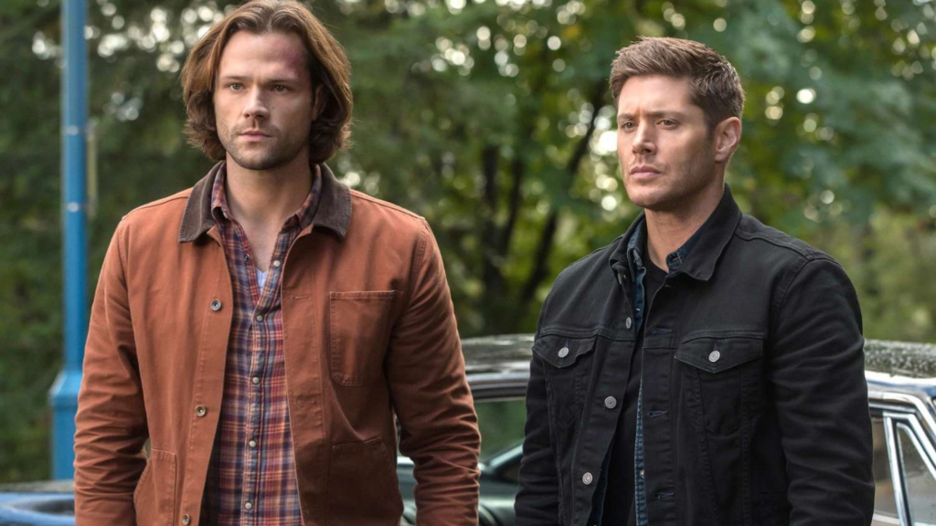 Jared Padalecki and Jensen Ackles as Sam and Dean Winchester standing in front of the Impala in Supernatural