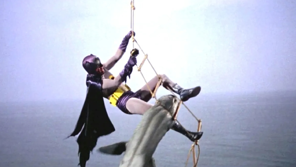 Batman on a rope ladder escaping a shark in Batman (1966)